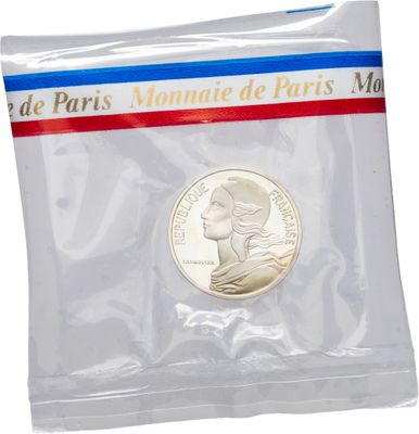 un gros plan d'une pièce de monnaie dans un sachet en plastique sur fond blanc