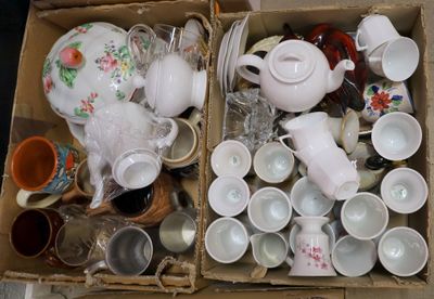 many cups and teapots in a box on the floor