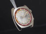 une montre en argent avec un cadran rouge et jaune sur fond noir