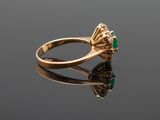 a gold ring with an emerald stone in the center