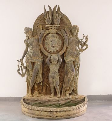 une statue représentant une horloge ornée d'anges, posée sur une table