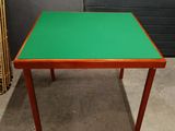 a small table with a green top on a concrete floor