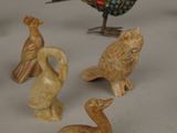 a lot of small figurines of birds on a table