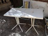 une table blanche et deux chaises disposées sur une terrasse