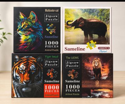 four puzzles of different animals are on a table next to a potted plant