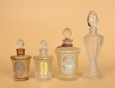 trois flacons de parfum en verre sont alignés sur une surface beige
