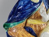 a figurine of a woman sitting on a chair