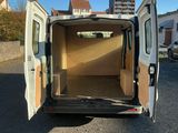 une camionnette blanche dont les portes sont ouvertes, garée sur un parking