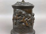 une urne antique en bronze ornée de chères et de chères