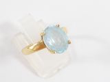 an image of a gold ring with a blue topaz stone