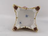 a small white plate with a brown and blue design on it