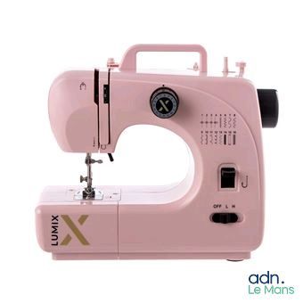 une machine à coudre rose posée sur une surface blanche