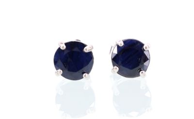 une paire de boucles d'oreilles à clous en saphir bleu sur fond blanc