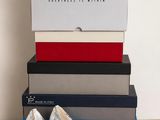une paire de chaussures blanches posée sur une pile de cartons