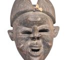 an image of a wooden mask with a hat on it ' s head