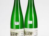 deux bouteilles de vin posées l'une à côté de l'autre sur une surface blanche