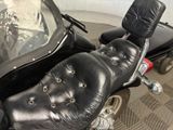 a black motorcycle with a black seat and a black bag on the back of it