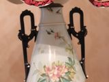 a white vase with a red ruffled top on a table
