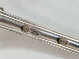 a silver spoon with a handle on a white surface