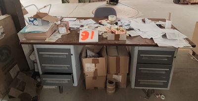 une table sur laquelle se trouvent de nombreuses boîtes et des papiers