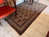 an image of a living room with red chairs and a rug