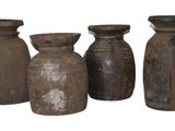 quatre vieux vases sont alignés sur un fond blanc