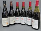 six bouteilles de vin sont alignées sur une table