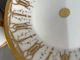 a gold and white plate with a clock on it
