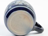 a close up of a blue and white coffee cup on a white surface