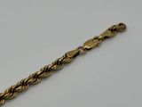 a close up of a gold bracelet on a white surface