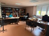 une salle où se trouvent de nombreux bureaux et chaises