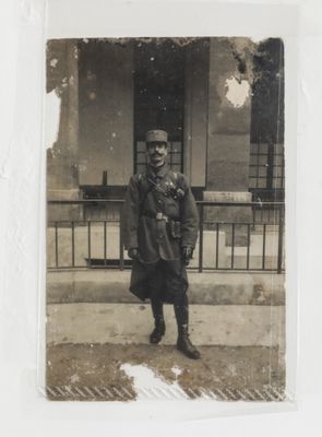 an old photo of a man standing on the sidewalk