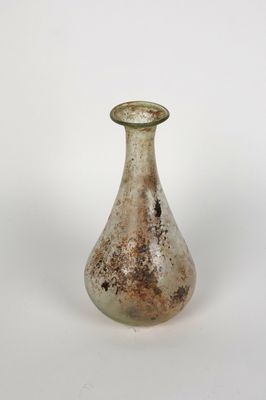 un petit vase en verre posé sur une surface blanche