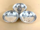 three metal bowls with a whisk in the middle of them