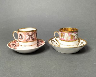 two cups and saucers are sitting on a gray surface