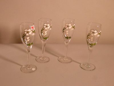 quatre verres à vin décorés de fleurs, posés sur une table