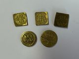 quatre pièces d'or posées sur une surface blanche