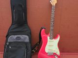 une guitare, un étui à guitare, une guitare et d'autres instruments de musique posés sur une table