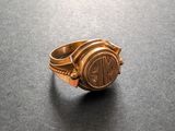 gros plan d'une bague en or sur une surface noire