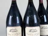 four bottles of wine are lined up on a table