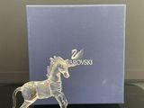 une figurine de licorne en verre transparent posée sur une table