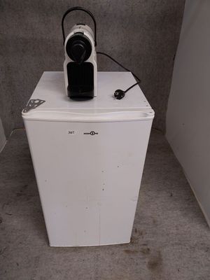un petit réfrigérateur blanc sur lequel est posée une cafetière