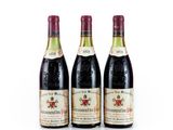 trois bouteilles de vin sont posées côte à côte sur une surface blanche