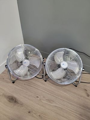 deux ventilateurs posés par terre l'un à côté de l'autre