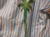 a shirt with a palm tree embroidered on it
