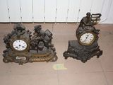 two clocks sitting on the floor next to each other