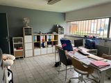 a room with a table, chairs, and a refrigerator in it