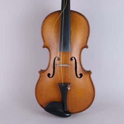 an old violin sitting on top of a white surface