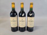 trois bouteilles de vin rouge posées côte à côte sur une table