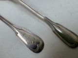 two spoons and a spoon rest on a table